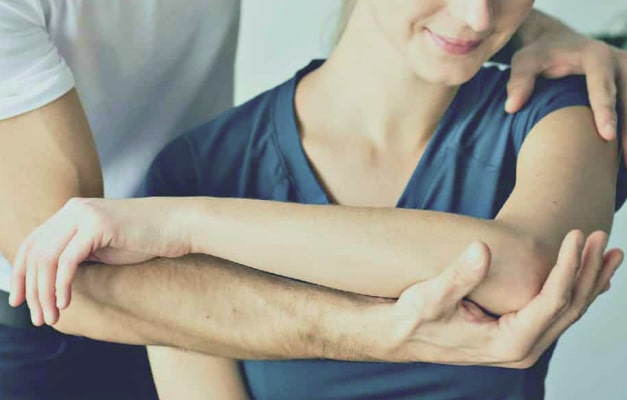 Patient moving elbow with assistance from therapist