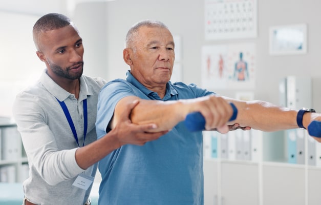 Patient lifting arms with weights through assistance of therapist