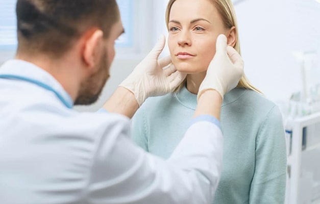 Physician examines a woman's face