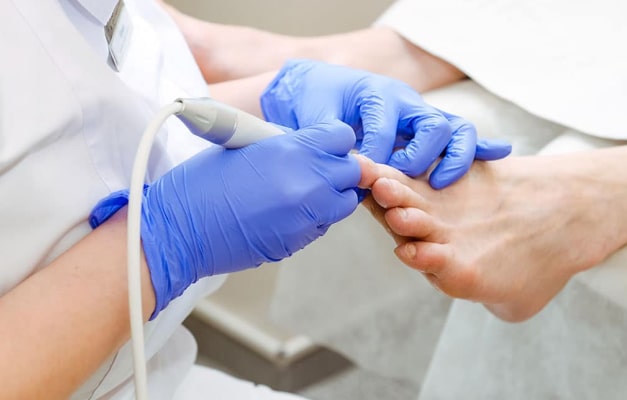 Medical professional uses tool on a patient's foot