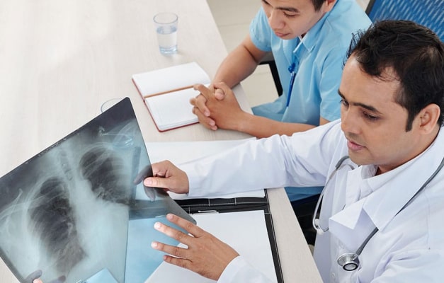 Medical staff review chest x-rays