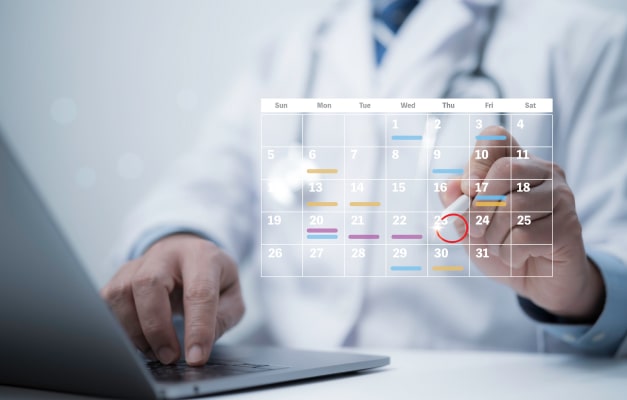 Medical professional types on a laptop with a digital calendar overlay