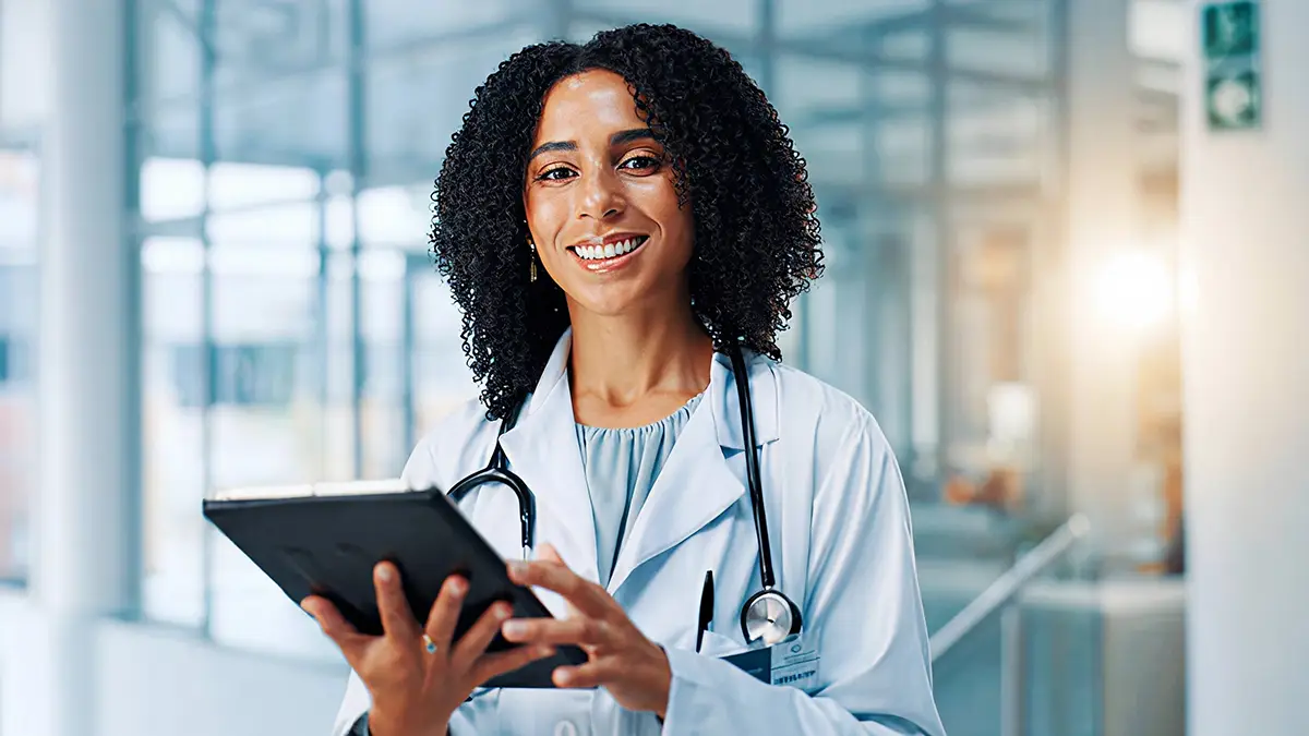 Medical professional smiling while holding a tablet
