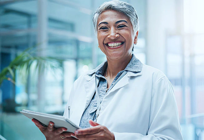 Medical professional holding a tablet smiling