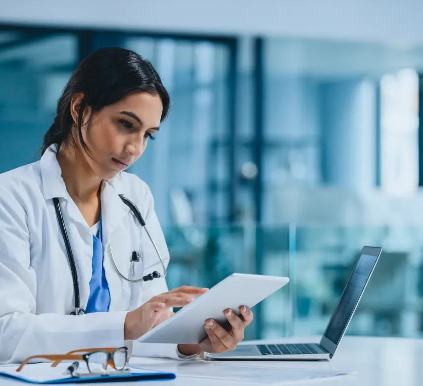 Physician reviewing tablet at a desk
