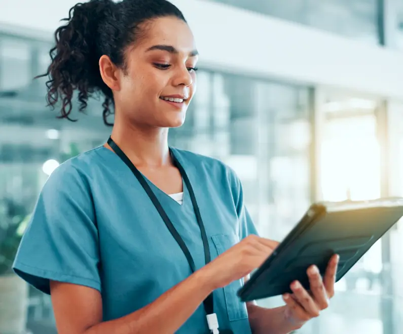 Medical professional reviews a tablet and smiles