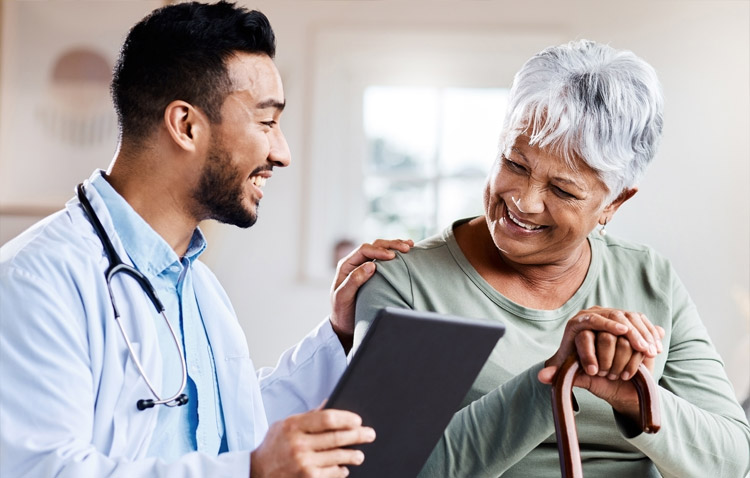 Physician smiling while showing a tablet to a patient