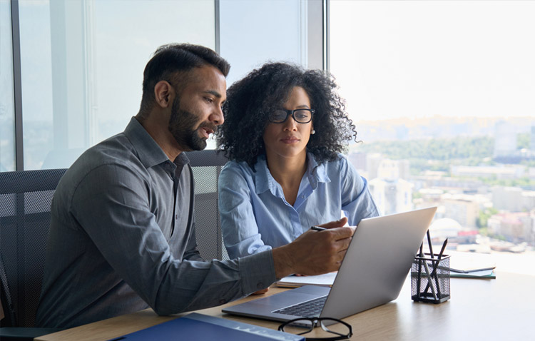 Two professionals reviewing a laptop screen together