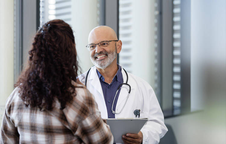 Physician smiling while speaking with a patient