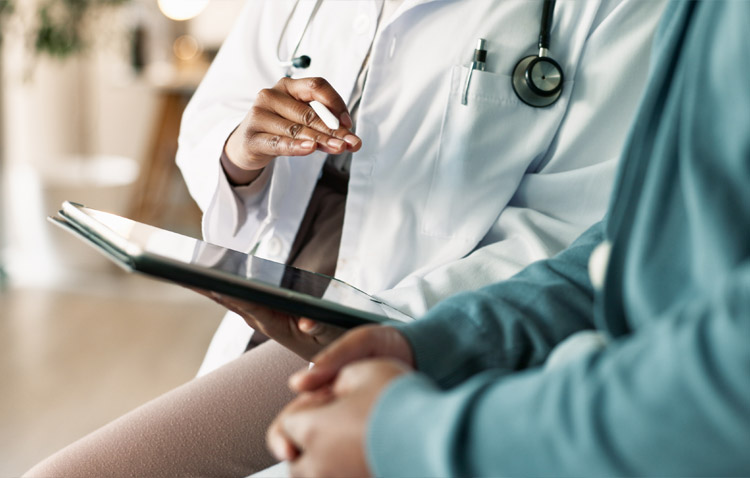 Close up of physician reviewing a tablet with a patient