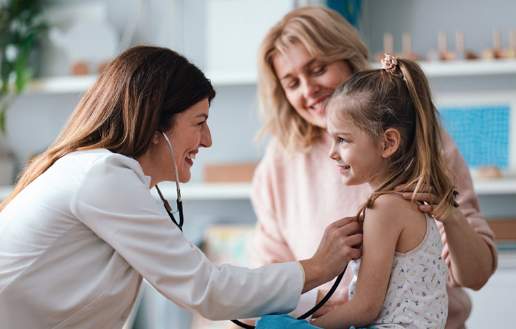 Physician interacting with pediatric patient and mom