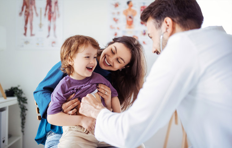 Physician interacting with pediatric patient and mom