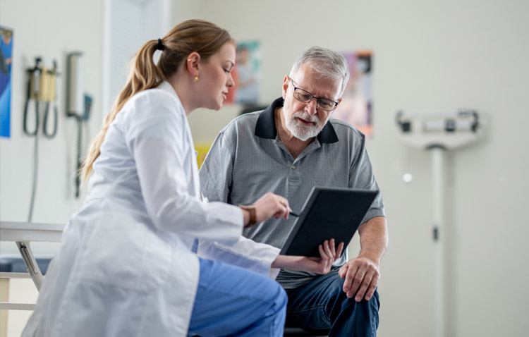 Physician reviews a tablet with a patient in a medical office