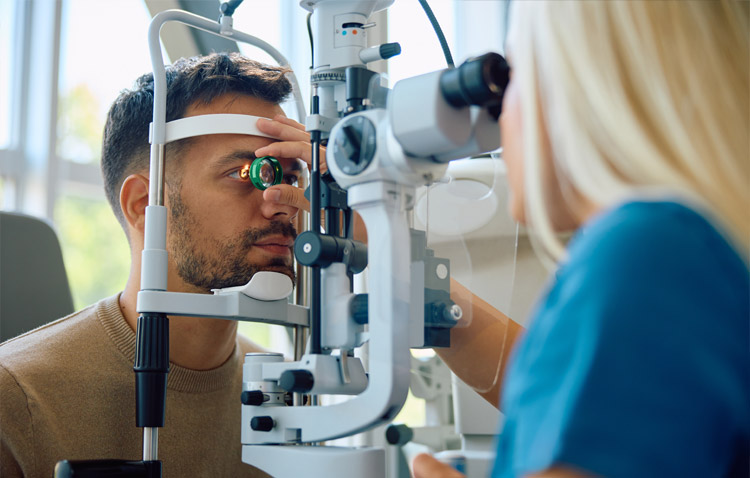 Medical professional examines a patient's eye through a machine