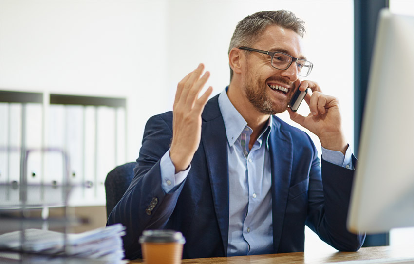 Business professional smiling while talking on mobile phone in office setting