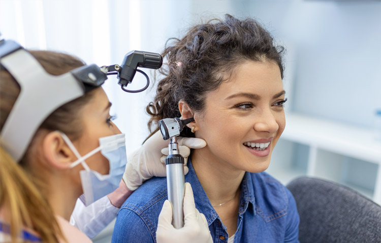Physician examines the inside of a patient's ear