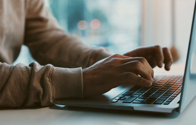 Close up of person typing on a laptop