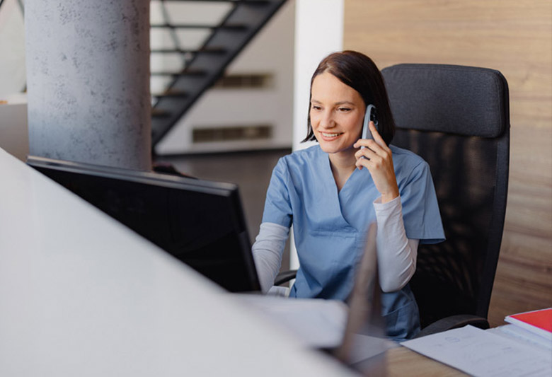 Nurse on talking on the phone at desk in office setting