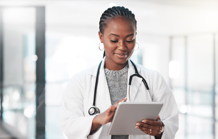 Physician smiling while looking at tablet