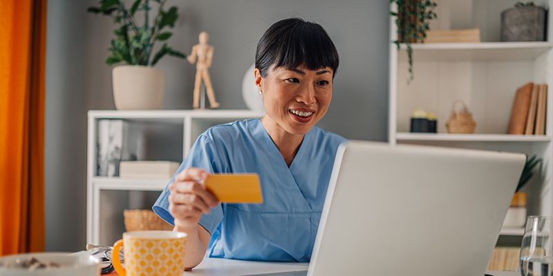 asian doctor in front of computer with credit card