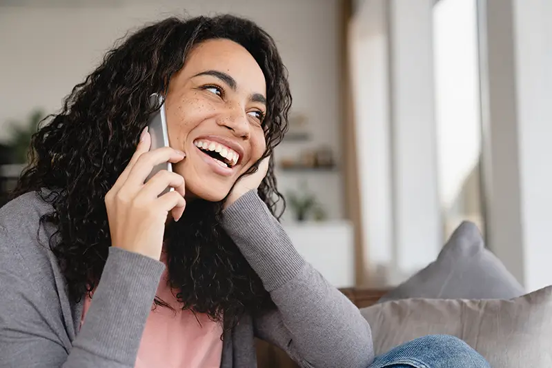 Young woman smiling at pleasant phone interraction