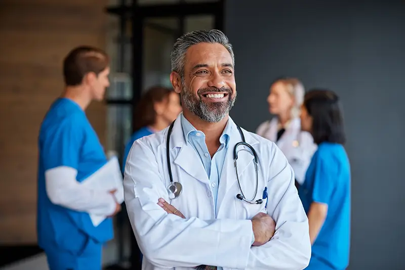 Capable Medical Doctor with staff behind him.