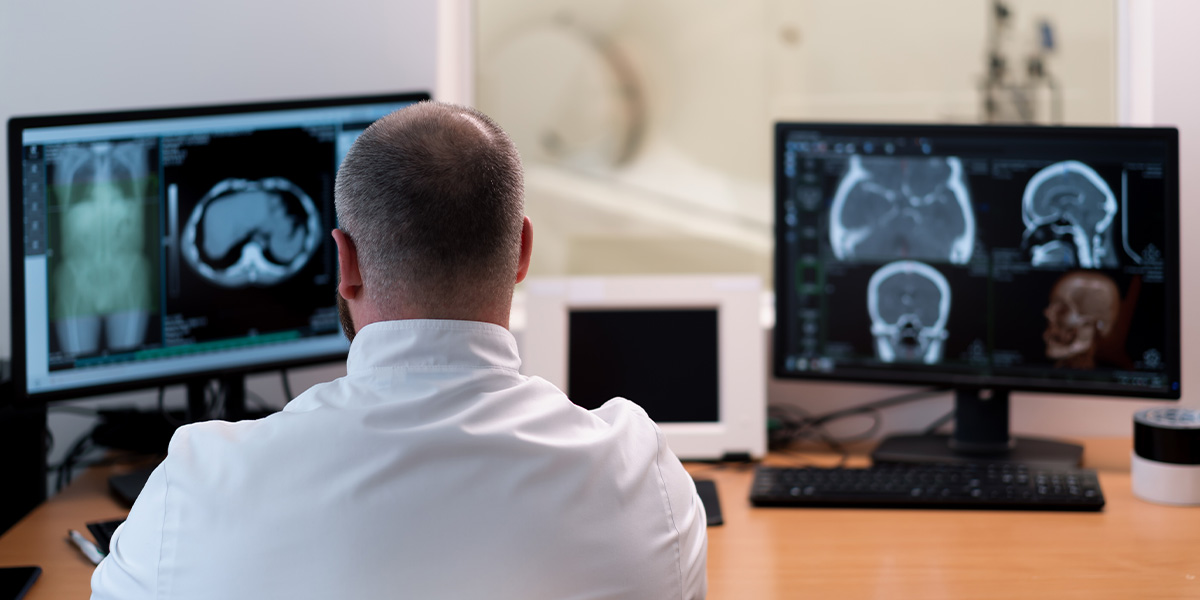 Radiologist actively reading MRI scans on a computer monitor